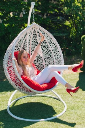 Белое подвесное кресло с красной подушкой радость девушки