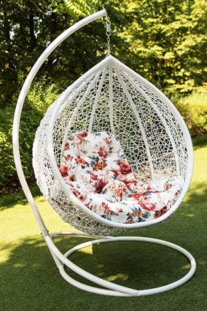 біле підвісне крісло з кольоровою подушкою