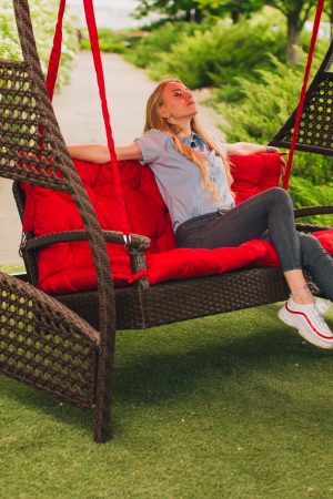 Дівчина на качелі з ротангу Рівьєра