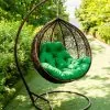 кресло кокон с зелёной подушкой из ротанга